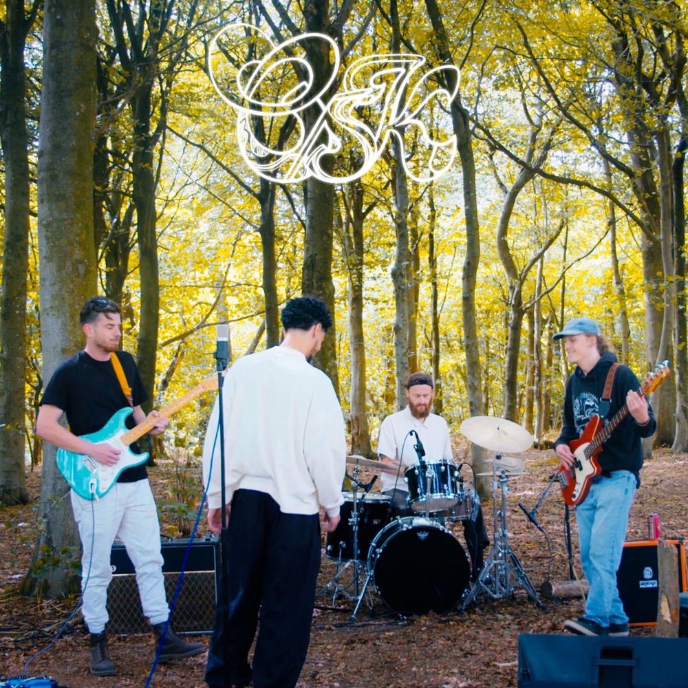 Care Package Live Session cover: the band playing guitar, bass and drums in a sunlit autumn wood, the OSK tag drawn in white across the top.